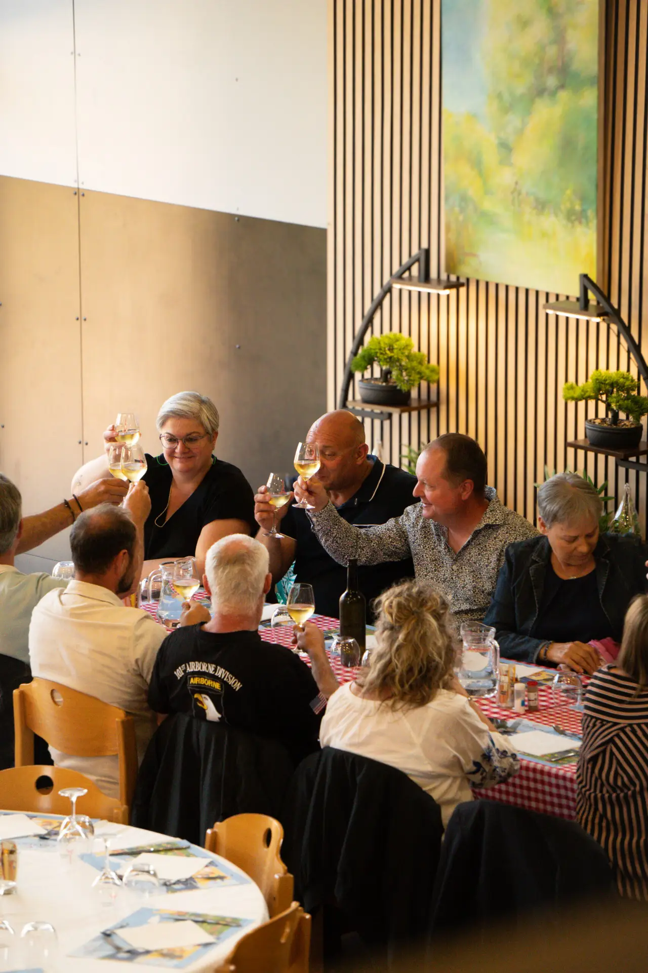 Groupe de convives partageant un repas en extérieur autour d'une table, photographie événementielle par Aptitude Pro.