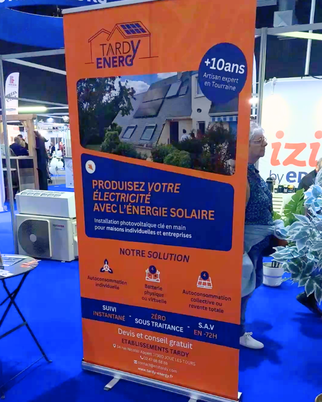 Kakémono orange Tardy Energy « Produisez votre électricité avec l'énergie solaire, +10 ans d'expérience » sur un salon professionnel, design print par Aptitude Pro.