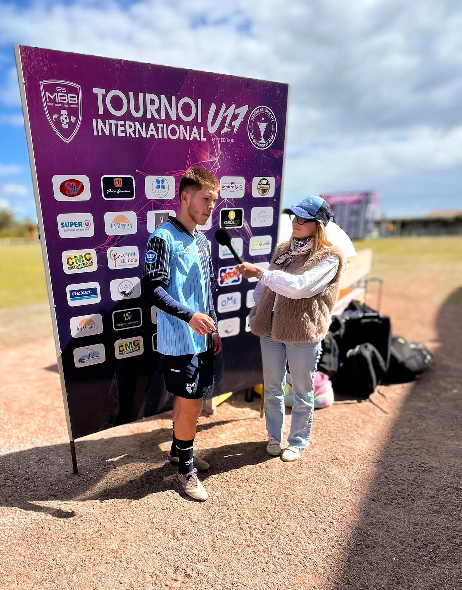 Jeune athlète interviewé devant la banderole du Tournoi International U17, création de contenu par Aptitude Pro.